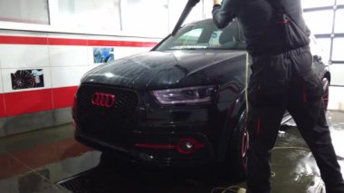 El yıkaması, özel bir hortumla arabasını yıkayan bir adam. El ile taşınabilir araba yıkama. Ayrıntılı ve nazik araba bakımı