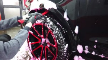 El yıkaması, özel bir hortumla arabasını yıkayan bir adam. El ile taşınabilir araba yıkama. Ayrıntılı ve nazik araba bakımı