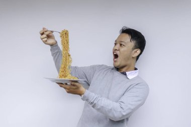 Shock 'un portresi ve Wow Asyalı genç adam eriştenin tadını çıkarıyor. Öğle yemeği konsepti..