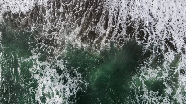 ビーチでの波への空中ビュー暗い砂で波をスプラッシング 青いターコイズきれいな波の海の水 — ストック写真