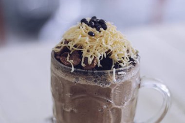 Çikolatalı milkshake, çikolatalı gevrek, peynir ve büyük cam bardakta çikolatalı cips. Üzerine seçici odaklanma ve bulanık arkaplan.