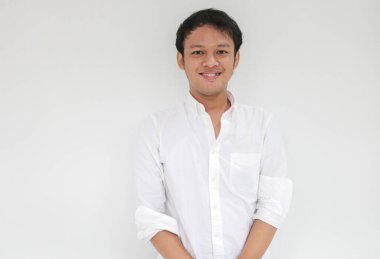 Beyaz gömlekli, kameraya bakıp gülümseyen Asyalı komik bir adamın portresi.