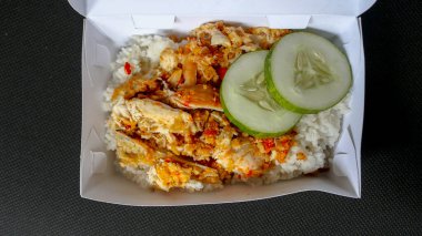 Beyaz arka planda izole edilmiş beyaz tabakta kırmızı biberli ve sarımsak aromalı Ayam geprek veya baharatlı tavuk ezmesi. Endonezya mutfağı baharatlı yemekleri.