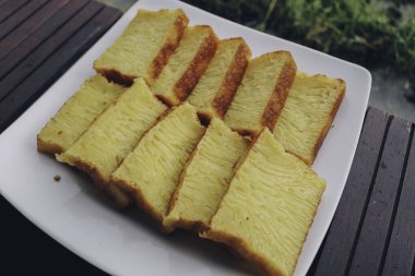 Bika Ambon, beyaz tabakta kare dilimlenmiş Endonezya pastası. Medan, Endonezya 'dan sarı pasta.
