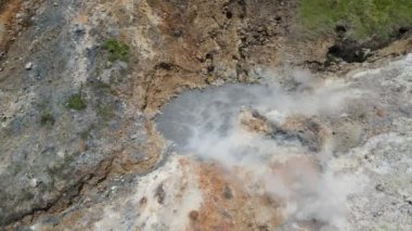 Sülfür bataklığından çıkan sülfür buharının arka planındaki Sikidang kraterinin hava görüntüsü.. 