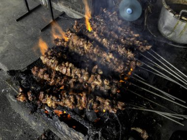 Keçi satay, insanlar tarafından kızartılıyor. Geleneksel Endonezya yemekleri koyun etinden yapılır.