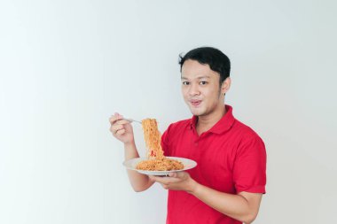 Genç Asyalı mutlu bir adamın portresi dilsiz eriştelerden hoşlanıyor. Öğle yemeği konsepti..