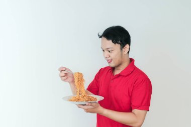 Genç Asyalı mutlu bir adamın portresi dilsiz eriştelerden hoşlanıyor. Öğle yemeği konsepti..