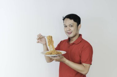 Genç Asyalı mutlu bir adamın portresi dilsiz eriştelerden hoşlanıyor. Öğle yemeği konsepti..