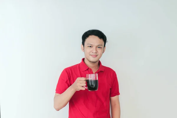 年轻的亚洲人 拿着一杯咖啡 站在孤独的白色背景上 带着大大的笑容 高兴极了 — 图库照片