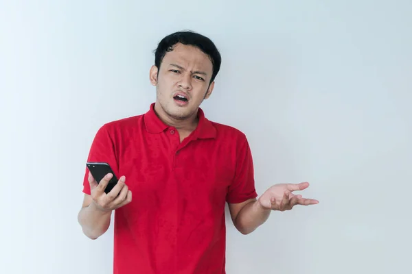 スマート若いアジアの男は混乱していると強調しているときにスタジオの背景にスマートフォンを見る — ストック写真