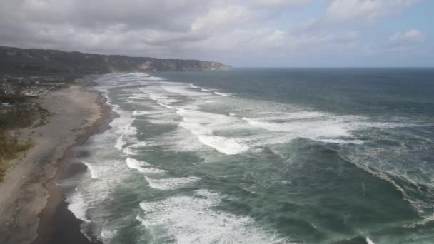 ビーチでの波への空中ビュー暗い砂で波をスプラッシング 青いターコイズきれいな波の海の水 — ストック動画