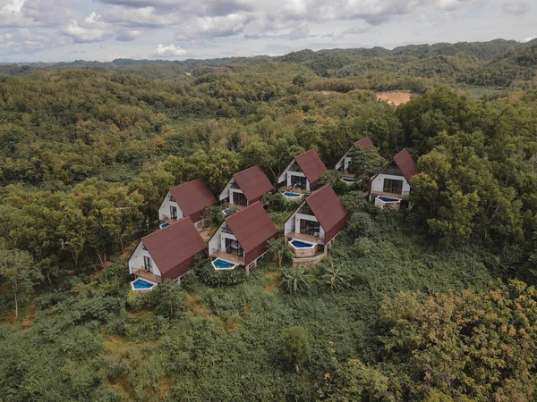 Aerial view of beautiful isolated villa with small swimming pool in the middle of a forest