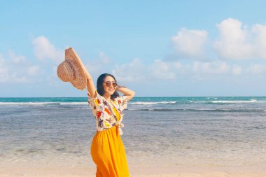 Sahilde gülümseyen Asyalı kadının portresi. Şapka tak.