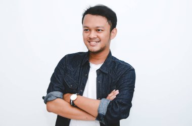 Beyaz gömlek ve kot pantolon giyen gülümseyen Asyalı genç adamın portresi..