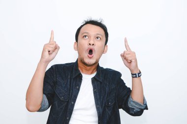 Beyaz tişörtlü, elleri boş Asyalı genç adamın şok olmuş yüzü..