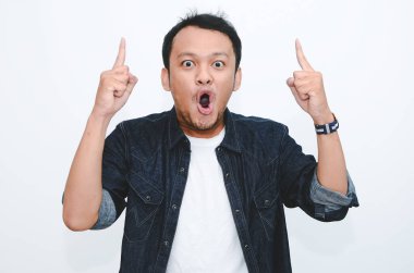 Beyaz tişörtlü, elleri boş Asyalı genç adamın şok olmuş yüzü..