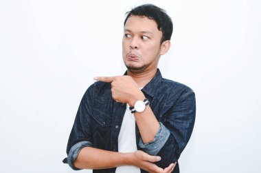 Boş alanda eli işaret eden gömlekli genç Asyalı adamın kızgın ve nefret dolu yüzü..