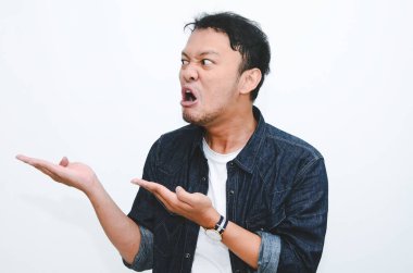 Boş alanda eli işaret eden gömlekli genç Asyalı adamın kızgın ve nefret dolu yüzü..