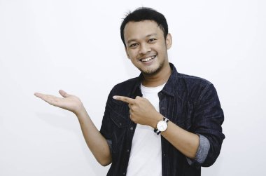 Beyaz tişörtlü, eli boş Asyalı genç adamın gülümsemesi.