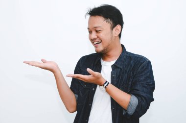 Beyaz tişörtlü, eli boş Asyalı genç adamın gülümsemesi.