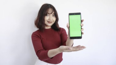 Asyalı güzel kız yeşil ekran telefonunda bulanık arkaplanı beyaz arkaplanlı.