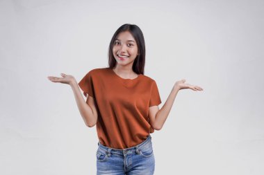 Kahverengi gömlekli güzel bir Asyalı kadın beyaz arka planla izole edilmiş fotokopi odasını sunuyor..