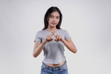 Çekici Asyalı genç bir kadın el hareketleriyle gri bir gömlek giyiyor. Beyaz arka planda fotokopi alanının yasaklanması veya reddedilmesi durumu var..