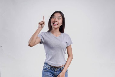 Üstündeki fotokopi odasını gösteren gri tişörtlü mutlu Asyalı kadın beyaz arka planla izole edilmiş..