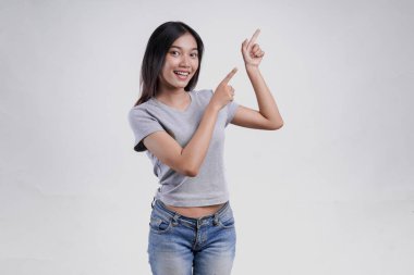 Üstündeki fotokopi odasını gösteren gri tişörtlü mutlu Asyalı kadın beyaz arka planla izole edilmiş..