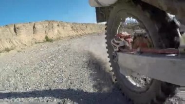 Tekerlek off-road motosiklet hareketi başlıyor. Kuru toprak ya da toz etrafta uçuşuyor