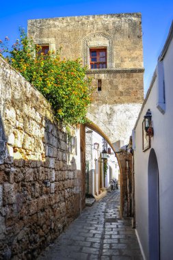 Küçük Lindos kasabası akropolün muazzam kayalarının arkasına saklanır. Kumlu kumsallarla iki koyu ayırır.  