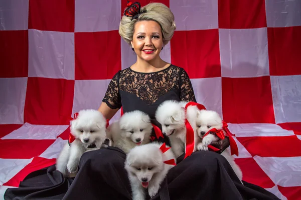 Счастливая женщина с белыми щенками — стоковое фото