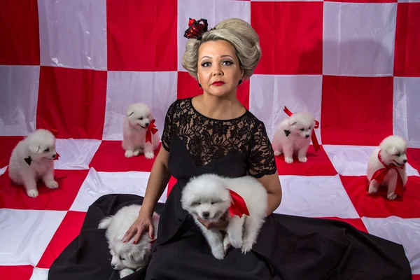 Mujer en corona con cachorros blancos — Foto de Stock