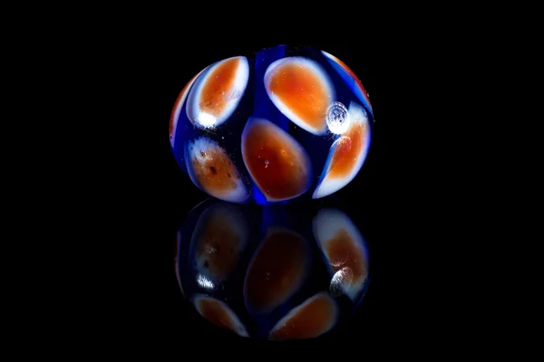 Conta de vidro laranja e azul com reflexão — Fotografia de Stock