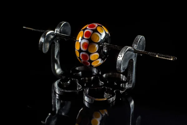 Orange and black glass bead on stand — Stock Photo, Image