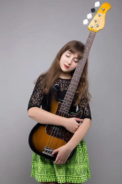 Blondes Teenager-Mädchen umarmt Bassgitarre — Stockfoto