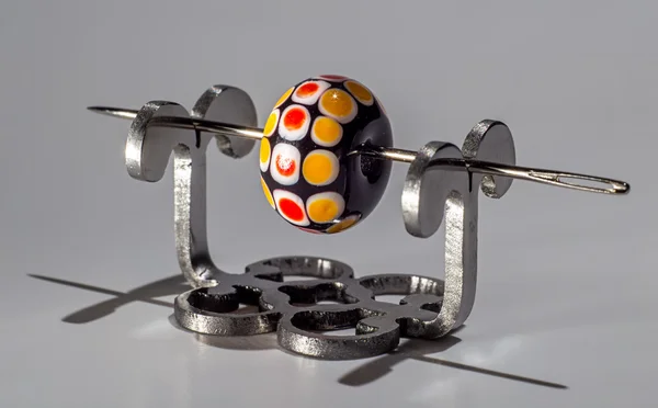 Black and orange glassy bead on the needle — Stock Photo, Image