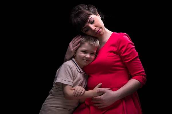 Нежная беременная мать и ее улыбающийся ребенок — стоковое фото