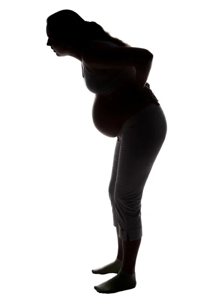 Silhouette of pregnant woman with low back pain — Stock Photo, Image