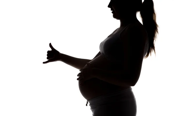 Силуэт беременной женщины, показывающей пальцы — стоковое фото