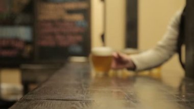 Adam bir bira bardağı masaya yakalar