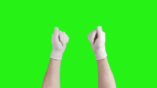 Video de manos masculinas quitándose guantes médicos blancos sobre fondo verde — Vídeos de Stock