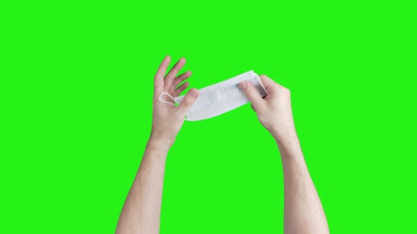 Video de manos masculinas mostrando máscara médica sobre fondo verde — Vídeos de Stock