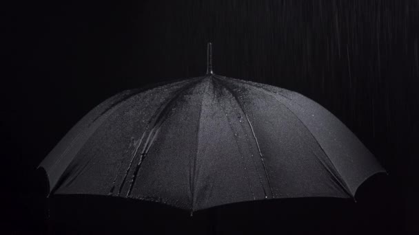 Schießen von Regenschirm und Regentropfen auf schwarzem Hintergrund — Stockvideo