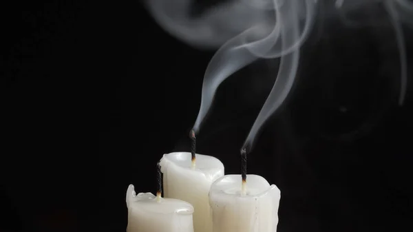 Tiros de três velas ardentes sobre fundo preto — Fotografia de Stock