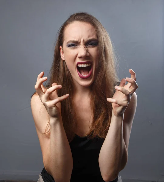 Imagen de mujer enojada con labios morados sobre fondo gris —  Fotos de Stock