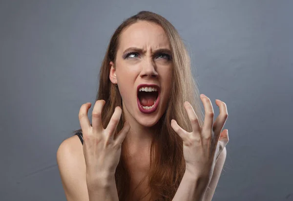 Zdjęcie wściekłej kobiety z jasnym makijażem na szarym tle — Zdjęcie stockowe