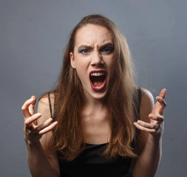 Wściekła kobieta z fioletowymi ustami na szarym tle — Zdjęcie stockowe