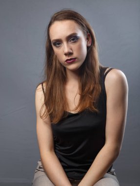 Gri arkaplanda mor dudaklı kadının fotoğrafı.